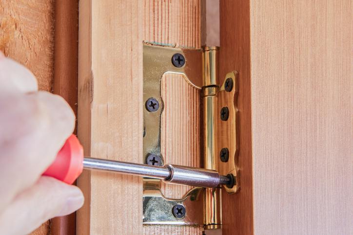 Tightening screws on a door hinge Tightening screws on a door hinge